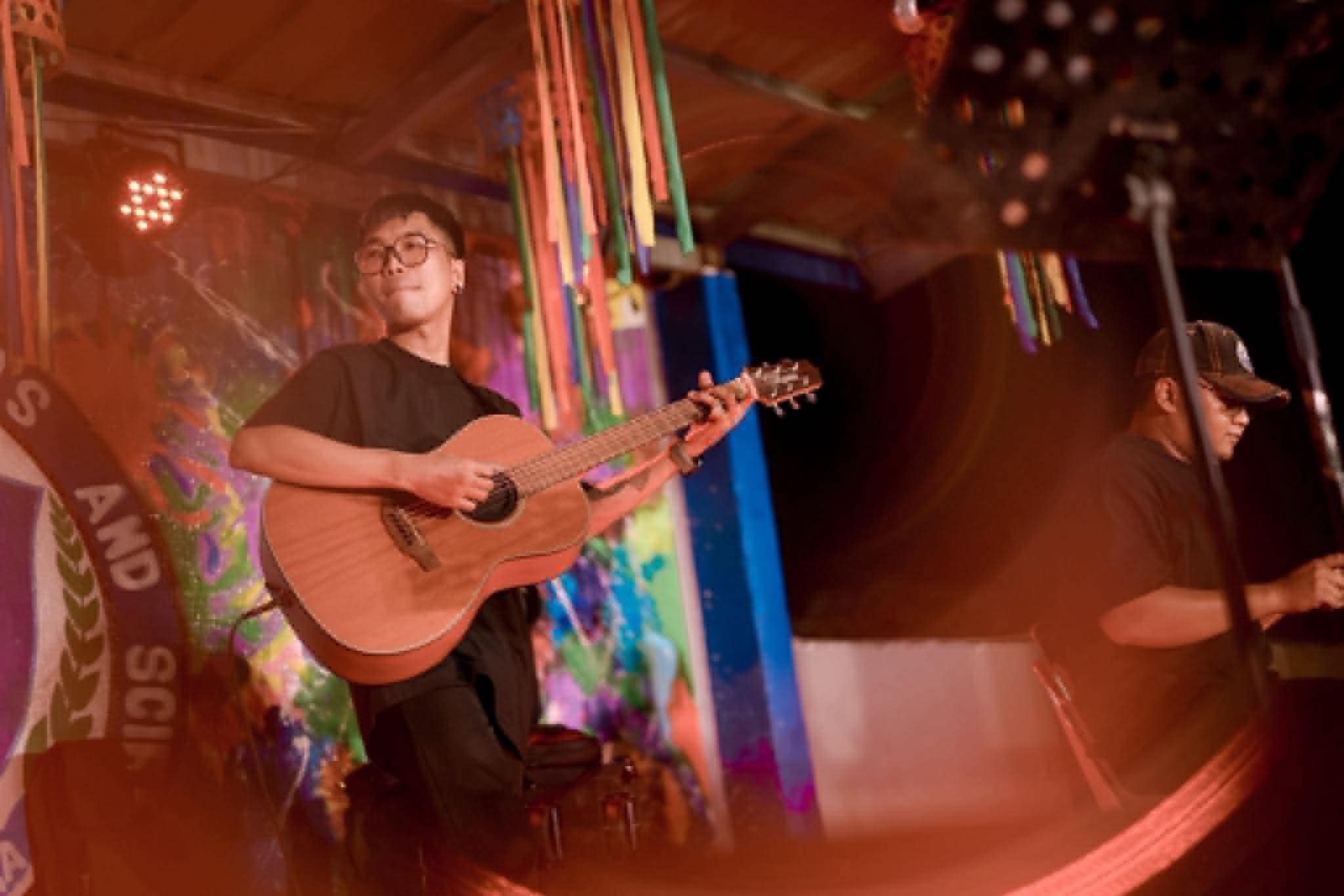Baldo on the red-lit stage with streamers